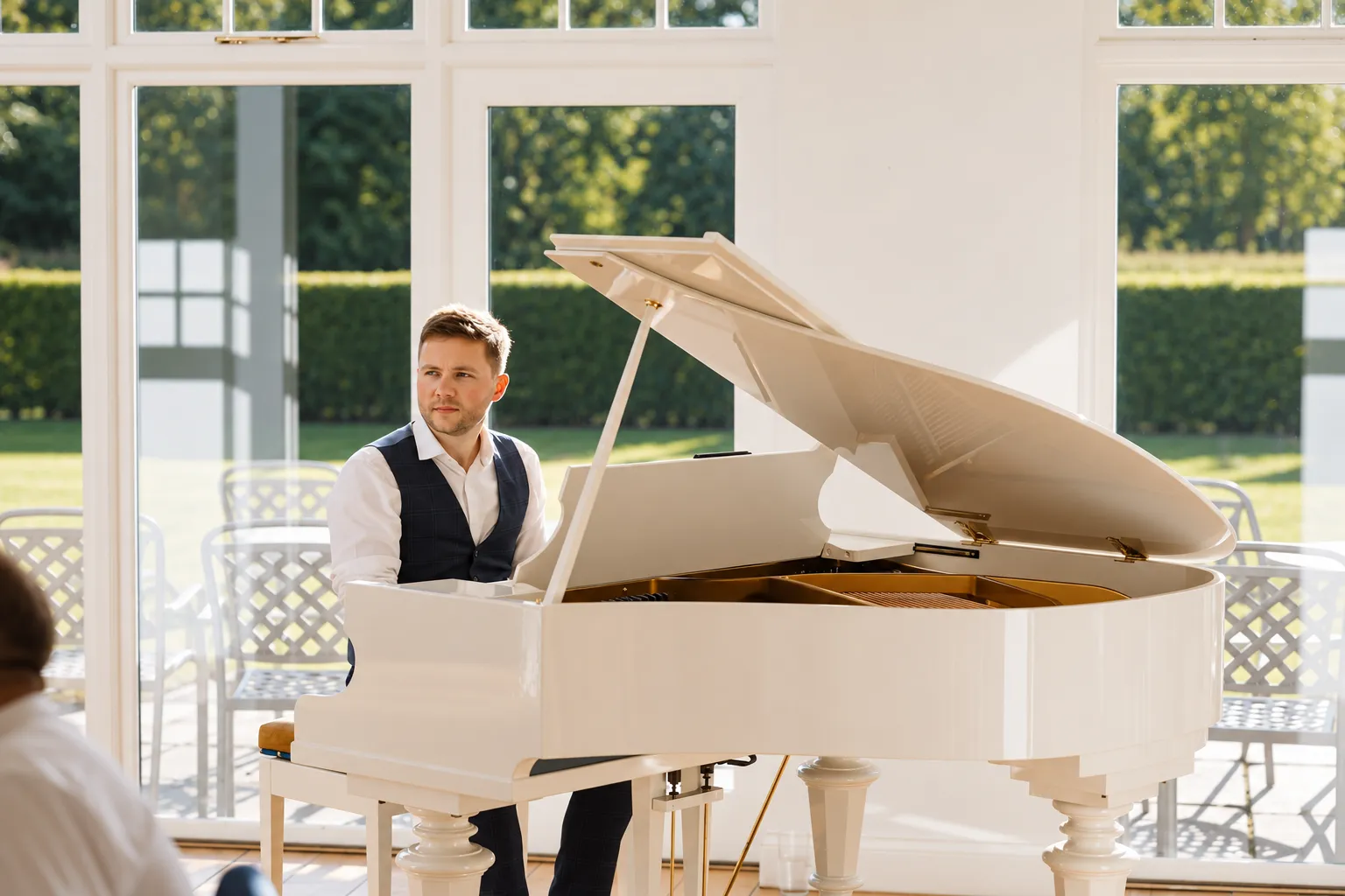 Finn at a white grand piano in the sunlit orangery at Hackness Grange
