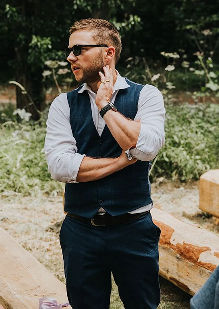 Finn outdoors in a navy waistcoat between sets