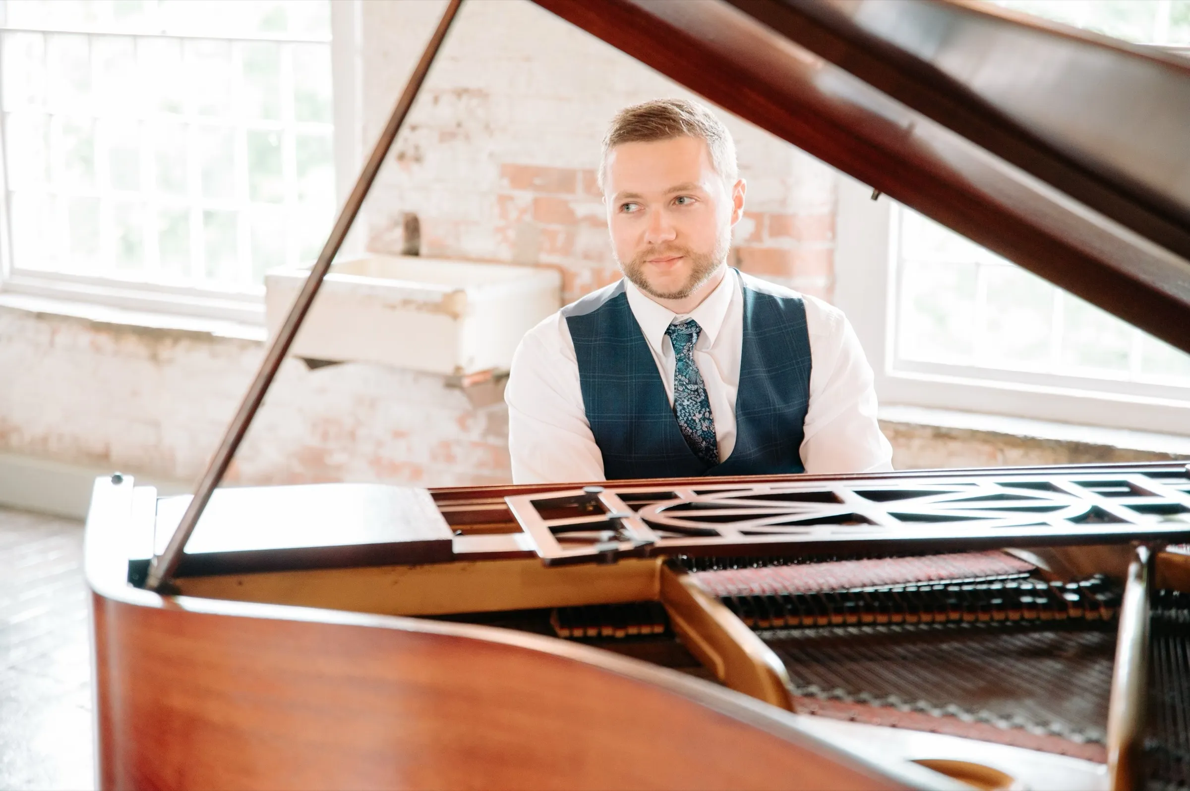 Finn at a grand piano in a bright mill venue